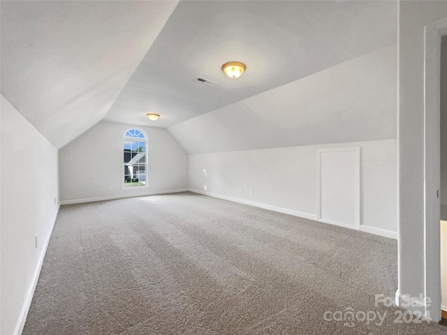 bonus room with lofted ceiling and carpet