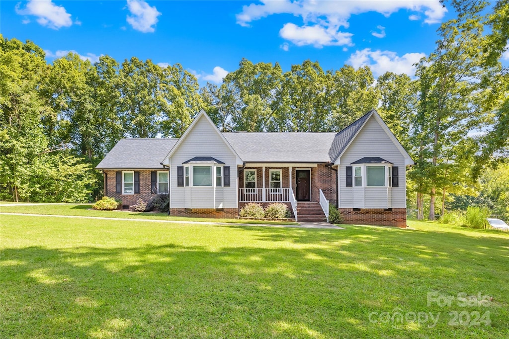 ranch-style home featuring a porch and a front lawn