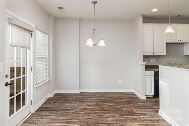 kitchen with dark hardwood / wood-style flooring, white cabinets, pendant lighting, and an inviting chandelier