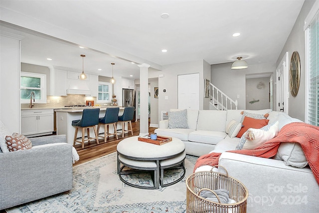 living room with ornate columns and light hardwood / wood-style floors