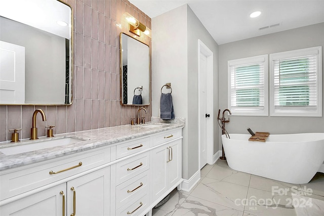 bathroom with a tub to relax in, vanity, and tasteful backsplash