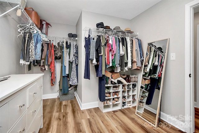 walk in closet with ceiling fan and light hardwood / wood-style floors