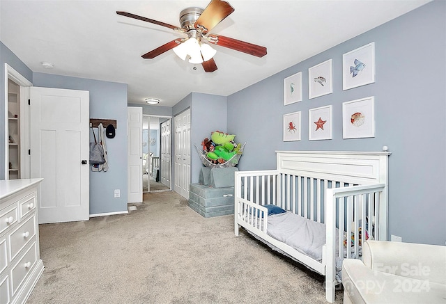 carpeted bedroom with ceiling fan and a closet