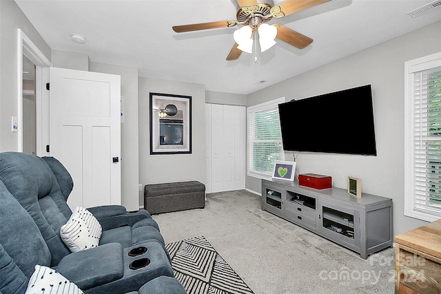 living room featuring ceiling fan, a wealth of natural light, and light carpet