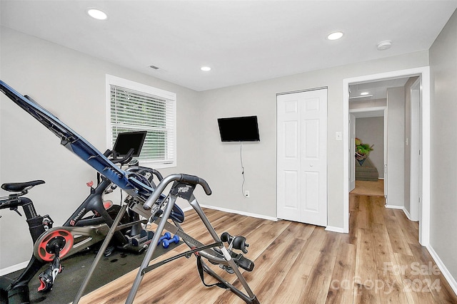 workout area with light hardwood / wood-style floors