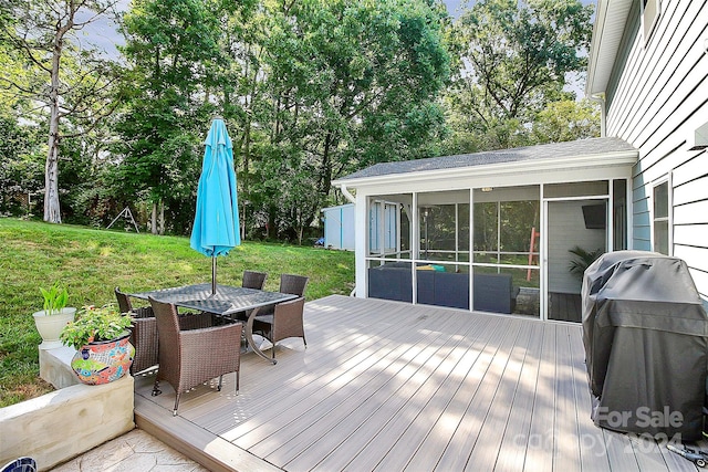 wooden terrace featuring a sunroom and a yard