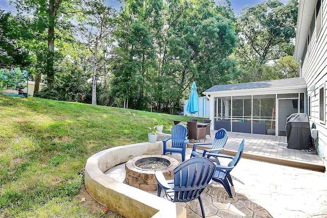 view of patio featuring a sunroom and an outdoor fire pit