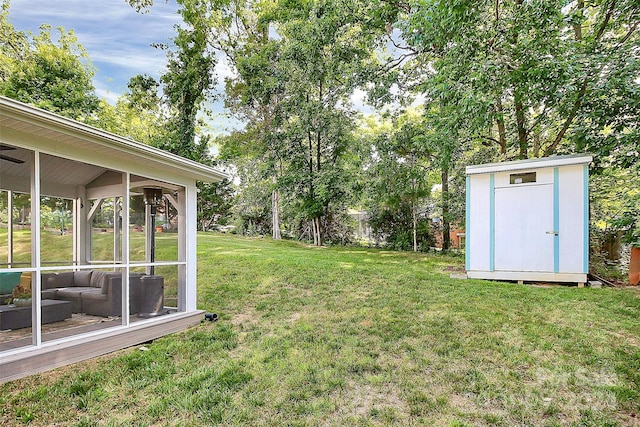 view of yard with a sunroom and a storage unit