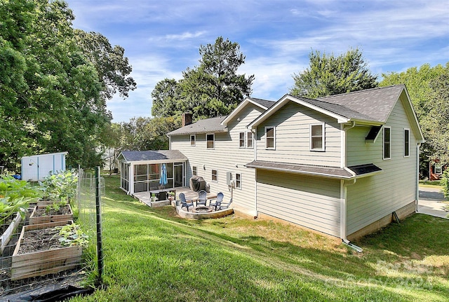 rear view of property with a lawn, a patio, and a sunroom