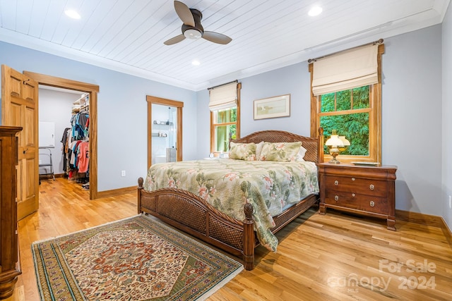 bedroom featuring ceiling fan, wood ceiling, light hardwood / wood-style flooring, a closet, and a spacious closet