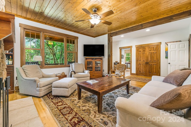 living room featuring ornamental molding, light wood-type flooring, ceiling fan, and wooden ceiling