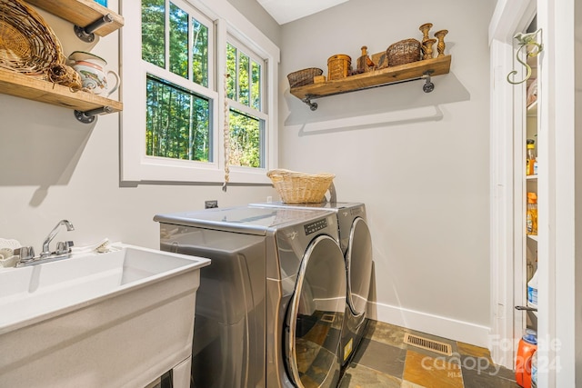 laundry room with separate washer and dryer and sink