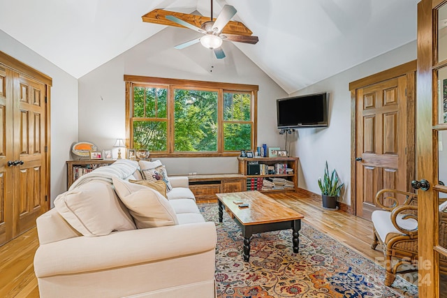 living room featuring light hardwood / wood-style flooring, lofted ceiling, and ceiling fan