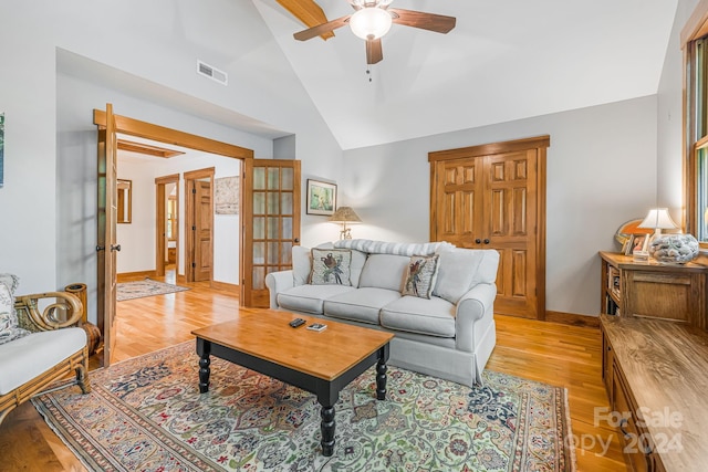 living room with ceiling fan, light hardwood / wood-style floors, and high vaulted ceiling