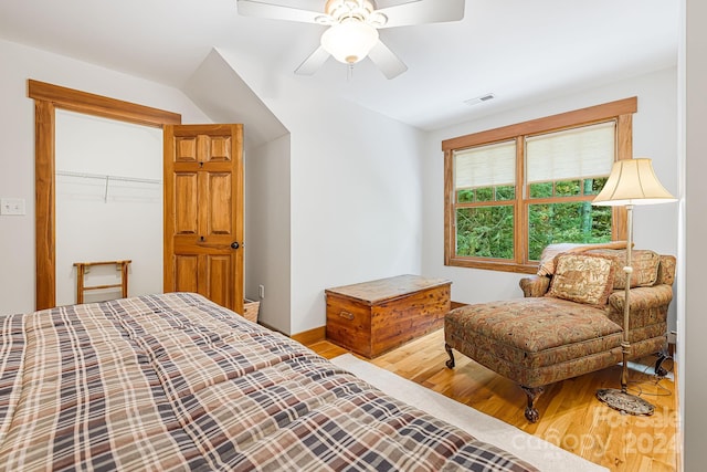 bedroom with ceiling fan, a closet, a walk in closet, and hardwood / wood-style floors