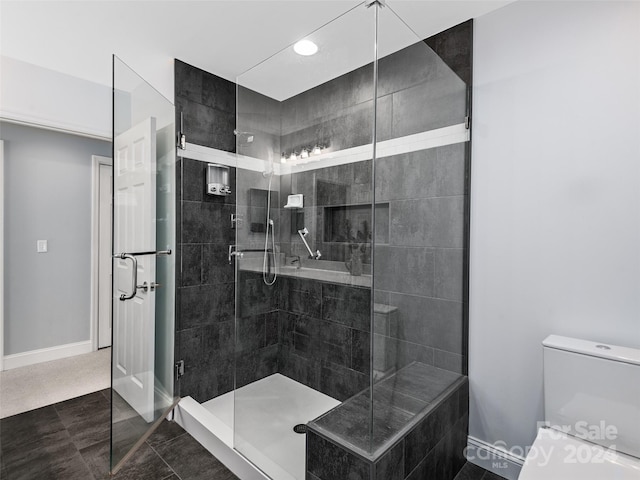 bathroom with tile patterned floors, a shower with shower door, and toilet