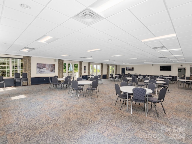 dining area featuring carpet flooring and a drop ceiling