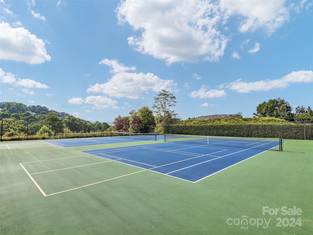 view of tennis court featuring basketball hoop