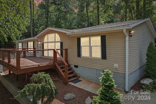 rear view of property featuring a wooden deck