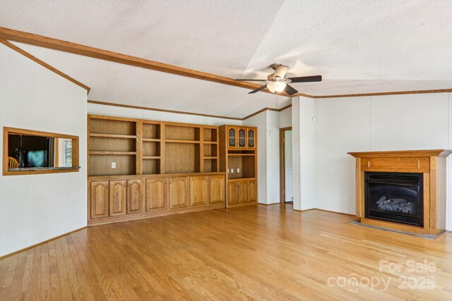18 Spencer Rd, Candler, NC 28715 - unfurnished living room featuring crown molding, a ceiling fan, light wood-type flooring, a textured ceiling, and a glass covered fireplace