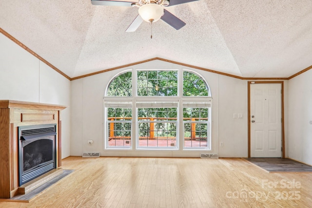 18 Spencer Rd, Candler, NC 28715 - unfurnished living room featuring vaulted ceiling, a textured ceiling, ornamental molding, a fireplace, and hardwood / wood-style floors
