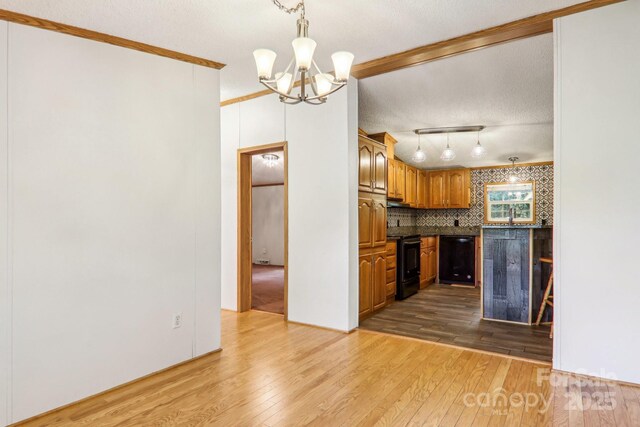 18 Spencer Rd, Candler, NC 28715 - kitchen with black appliances, light wood-style flooring, a chandelier, dark countertops, and crown molding