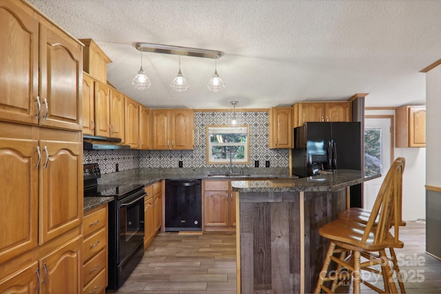 18 Spencer Rd, Candler, NC 28715 - kitchen with black appliances, under cabinet range hood, a sink, a textured ceiling, and light wood-style floors