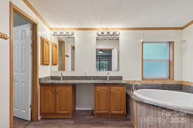 18 Spencer Rd, Candler, NC 28715 - bathroom featuring a textured ceiling, double vanity, crown molding, a bath, and wood finished floors