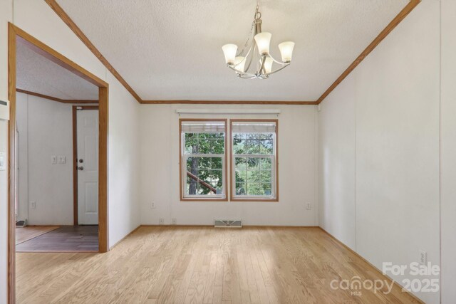 18 Spencer Rd, Candler, NC 28715 - empty room featuring crown molding, a chandelier, light wood finished floors, and a textured ceiling