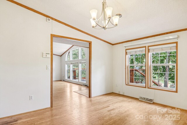 18 Spencer Rd, Candler, NC 28715 - empty room featuring vaulted ceiling, a chandelier, ornamental molding, a textured ceiling, and wood finished floors
