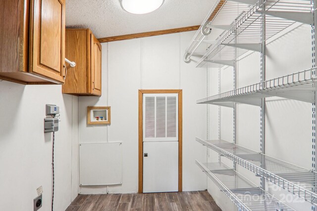 18 Spencer Rd, Candler, NC 28715 - laundry area featuring cabinet space, a heating unit, hookup for an electric dryer, wood finished floors, and washer hookup