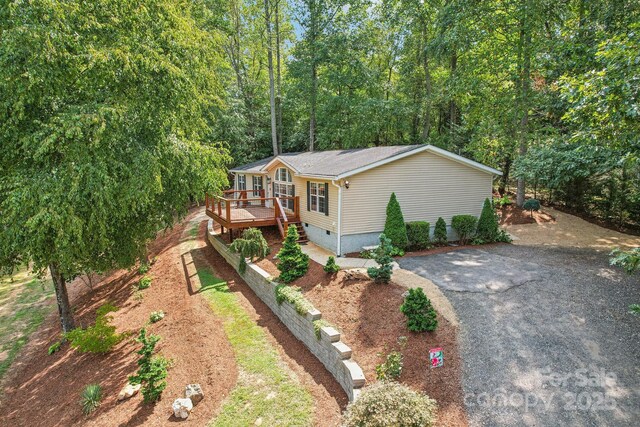 18 Spencer Rd, Candler, NC 28715 - view of front facade with a wooden deck, crawl space, driveway, and a wooded view