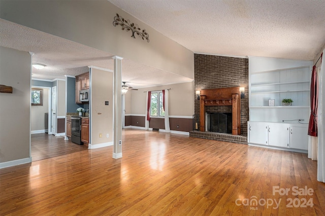 unfurnished living room featuring lofted ceiling, light hardwood / wood-style flooring, a textured ceiling, and ceiling fan