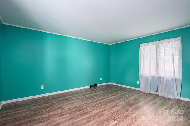 spare room featuring ornamental molding and wood-type flooring