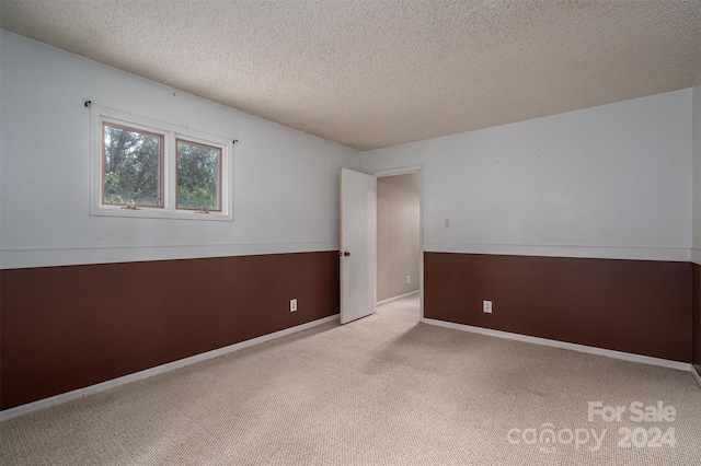 carpeted empty room with a textured ceiling