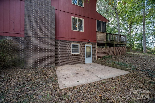 back of house with a wooden deck and a patio area