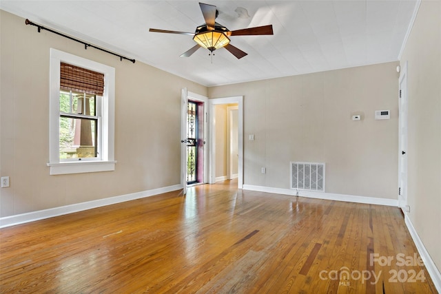 empty room with hardwood / wood-style floors and ceiling fan