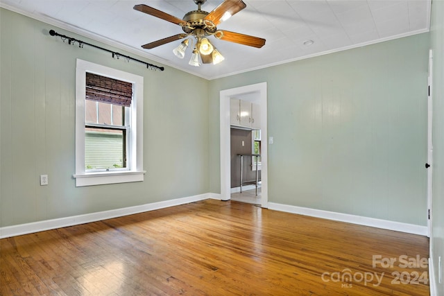 unfurnished room featuring wood-type flooring, ornamental molding, and ceiling fan