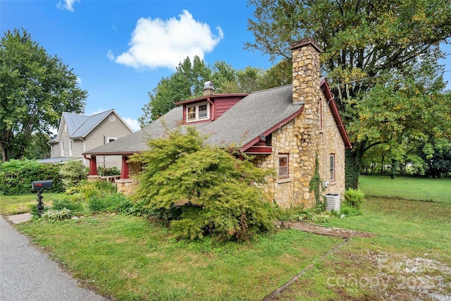 view of front of house featuring a front yard and cooling unit