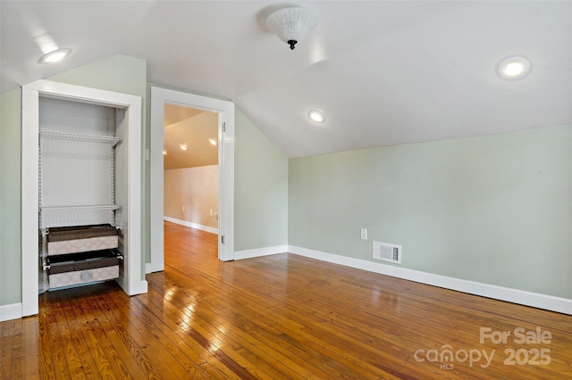 additional living space featuring dark hardwood / wood-style flooring and vaulted ceiling