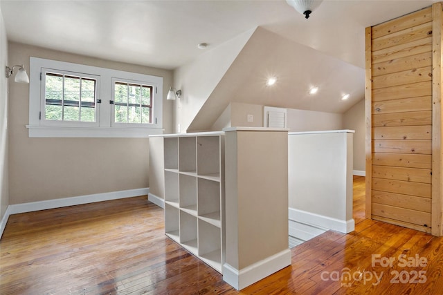 additional living space featuring wood-type flooring and vaulted ceiling