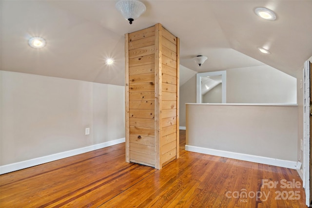 additional living space featuring lofted ceiling and wood-type flooring