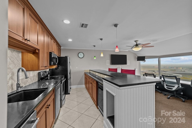 kitchen featuring appliances with stainless steel finishes, decorative backsplash, pendant lighting, ceiling fan, and sink