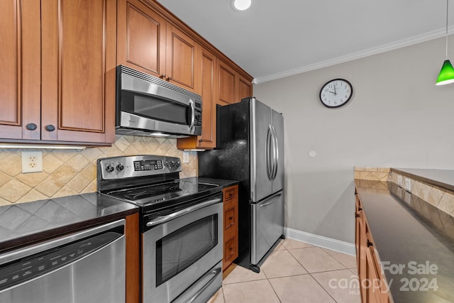 kitchen featuring light tile patterned flooring, appliances with stainless steel finishes, crown molding, and decorative backsplash