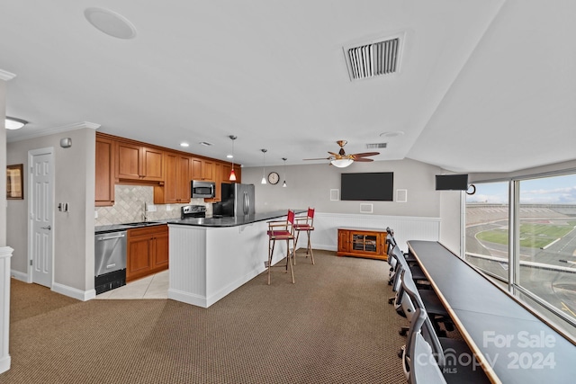 kitchen with sink, light colored carpet, appliances with stainless steel finishes, decorative light fixtures, and ceiling fan