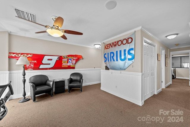 living area with crown molding, carpet, and ceiling fan