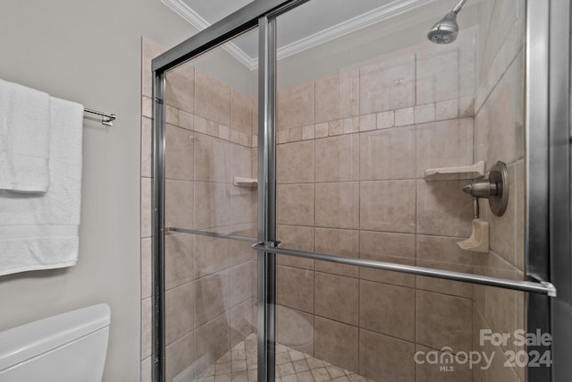 bathroom with ornamental molding, a shower with shower door, and toilet