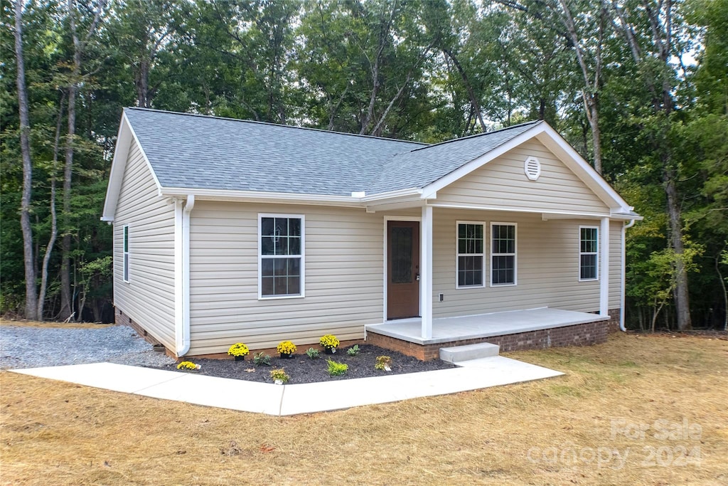 ranch-style house featuring a porch and a front lawn