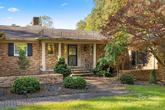 ranch-style home with brick siding and a chimney