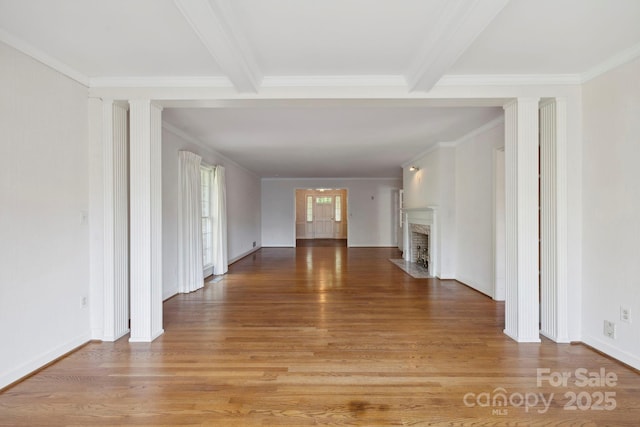 interior space featuring beamed ceiling, ornamental molding, and hardwood / wood-style flooring